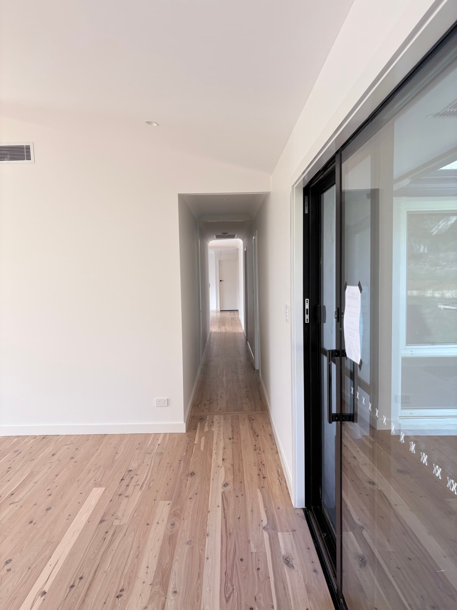 Modern hallway painted in white with contrasting doors, Orange NSW